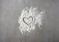 Heart shape in flour on grey kitchen table