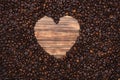 Heart shape frame of coffee beans on wooden background. Royalty Free Stock Photo
