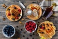 Heart shape gaufre with maple syrup and forest fruits on rustic wooden table