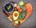 Heart shape of ketogenic low carbs diet concept. Ingredients for healthy foods selection on dark stone background. Balanced