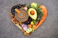 Heart shape of ketogenic low carbs diet concept. Ingredients for healthy foods selection on dark stone background. Balanced