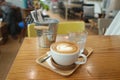 Heart shape latte art coffee on the timber table in coffee shop