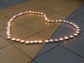 Heart Shape of lit candles on the floor Royalty Free Stock Photo