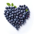 Heart shape made from blueberries with green leaves, isolated on white background