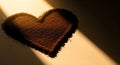Heart shape made of coffee grounds illuminated by a dramatic light beam, symbolizing love for coffee Royalty Free Stock Photo