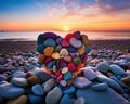 heart shape made of colorful stones is on the beach at sunset. Royalty Free Stock Photo