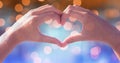 Heart shape made of hands over defocused background Royalty Free Stock Photo