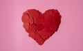 Heart shape made of heart shaped paper confetti with blank pink background