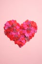 Heart shape made of hearts confetti on pink table. Top view, flat lay. Minimal style. Happy Valentines Day concept Royalty Free Stock Photo