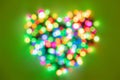 Heart shape made of multi-colored circles of lights on bright green background. Flat lay background for Valentines Day Royalty Free Stock Photo