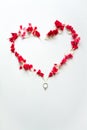 Heart shape made by red carnation petals with ring