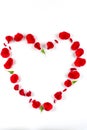 Heart shape made of red rose petals, on white background. Top view, copy space Royalty Free Stock Photo