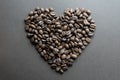 Heart shape made of roasted coffee beans on dark background