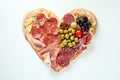 Heart shape made of traditional Spanish tapas, ham, salami, cheese and olives with bread. Flat lay with assorted appetizers for Royalty Free Stock Photo