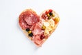 Heart shape made of traditional Spanish tapas, ham, salami, cheese and olives with bread. Flat lay with assorted appetizers for Royalty Free Stock Photo