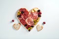 Heart shape made of traditional Spanish tapas, ham, salami, cheese and olives with bread. Flat lay with assorted appetizers for Royalty Free Stock Photo