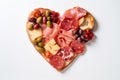 Heart shape made of traditional Spanish tapas, ham, salami, cheese and olives with bread. Flat lay with assorted appetizers for Royalty Free Stock Photo