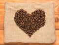 Heart shape made up of coffee beans on burlap. wooden background. the concept of dating and meeting, love and adventure. rustic Royalty Free Stock Photo