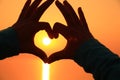 Heart shape making of hands against bright sea sunset Royalty Free Stock Photo