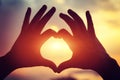 Heart shape making of hands against bright sea sunset Royalty Free Stock Photo