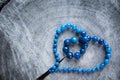 Heart shape from necklace of dark blue faceted agate on the rough surface of an old stump. Valentine`s Day greeting card Royalty Free Stock Photo