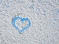 Heart shape painted by finger on frozen window covered with fresh white snow Royalty Free Stock Photo