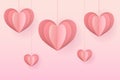 Heart shape paper carved elements hanging on pink background. Symbols of love for Valentine's day, happy