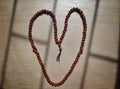 Heart shape of prayer beads on a wooden background Royalty Free Stock Photo