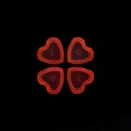 Heart shape red jellies contain letter LOVE on black background.