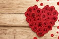 The heart shape from red roses and rose petals on wooden table background Royalty Free Stock Photo