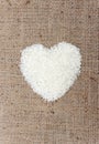 Heart shape rice grains on old sack background. Royalty Free Stock Photo