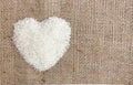 Heart shape rice grains on old sack background. Royalty Free Stock Photo