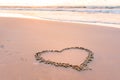 Heart shape on a sandy seaside beach drawn with a wooden stick Royalty Free Stock Photo
