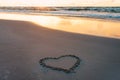 Heart shape on a sandy seaside beach drawn with a wooden stick Royalty Free Stock Photo