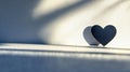 Heart shape with soft shadows on sunlit textured surface in minimalistic concept