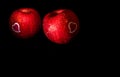 Heart shape sticker and water droplet on glossy surface of red apple on black background Royalty Free Stock Photo