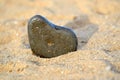 Heart shape stone against background of beach. Summer sunny day. Love, wedding and Valentine day concept. Finding Royalty Free Stock Photo