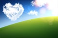 Heart shape white clouds on blue sky background. Green hill. Valentine`s day Royalty Free Stock Photo