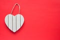 Heart shape wooden sign board frame hanging on a rope on red background with copy space Royalty Free Stock Photo