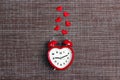 Heart-shaped alarm clock and hearts on sackcloth background. Time for love and greetings Royalty Free Stock Photo