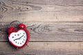 Heart-shaped alarm clock on old woooden background. Place for t