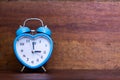 Heart shaped alarm clock on wooden background. Three O Clock Royalty Free Stock Photo