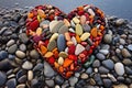 a heart-shaped arrangement of colorful pebbles on the shore Royalty Free Stock Photo