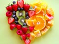 A heart shaped arrangement of fruit on a green background Royalty Free Stock Photo