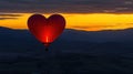 Heart-shaped balloon sunrise flight over mountains Royalty Free Stock Photo