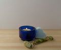 A heart shaped bath bomb, a jade roller and a burning candle Royalty Free Stock Photo