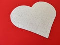 Heart shaped blank white jigsaw puzzle on red background puzzle pieces completing the heart shape Royalty Free Stock Photo