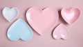 Heart shaped blue, pink and white empty plates on pink background. Happy Valentine`s Day