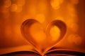 Heart shaped book on gold bokeh background Royalty Free Stock Photo