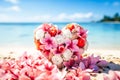 Holiday heart shaped bouquet of pink frangipani and white roses on sandy shore Royalty Free Stock Photo